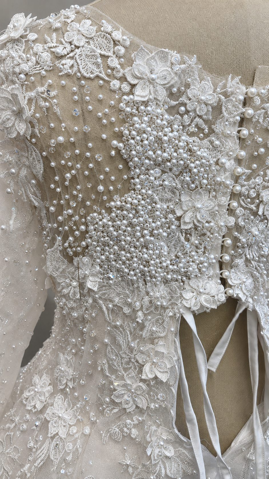 Close up of hand appliquéd lace with pearl and crystal beadwork