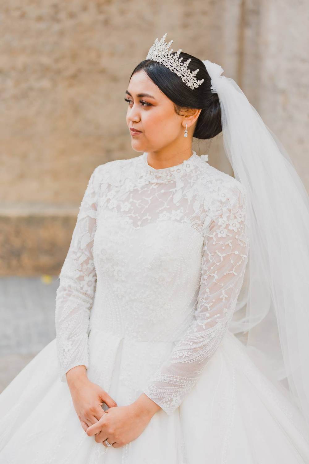 Bride in a high neck lace gown and pearl veil by Saarahjasmin Couture